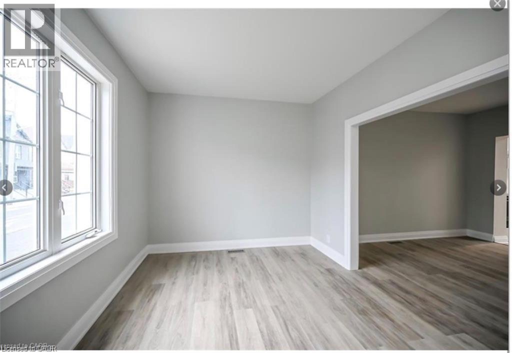 Spare room featuring light wood finished floors and plenty of natural light - 1024 Cannon Street E, Hamilton, ON - Indoor Photo Showing Other Room