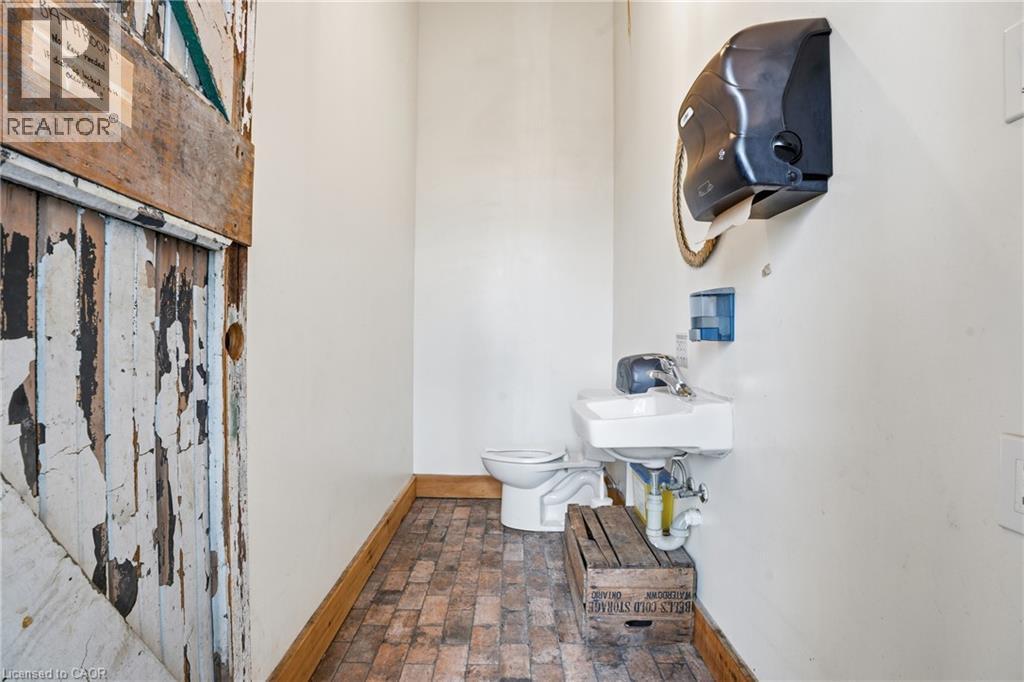 Bathroom featuring toilet and brick flooring - 204 Ottawa Street N, Hamilton, ON