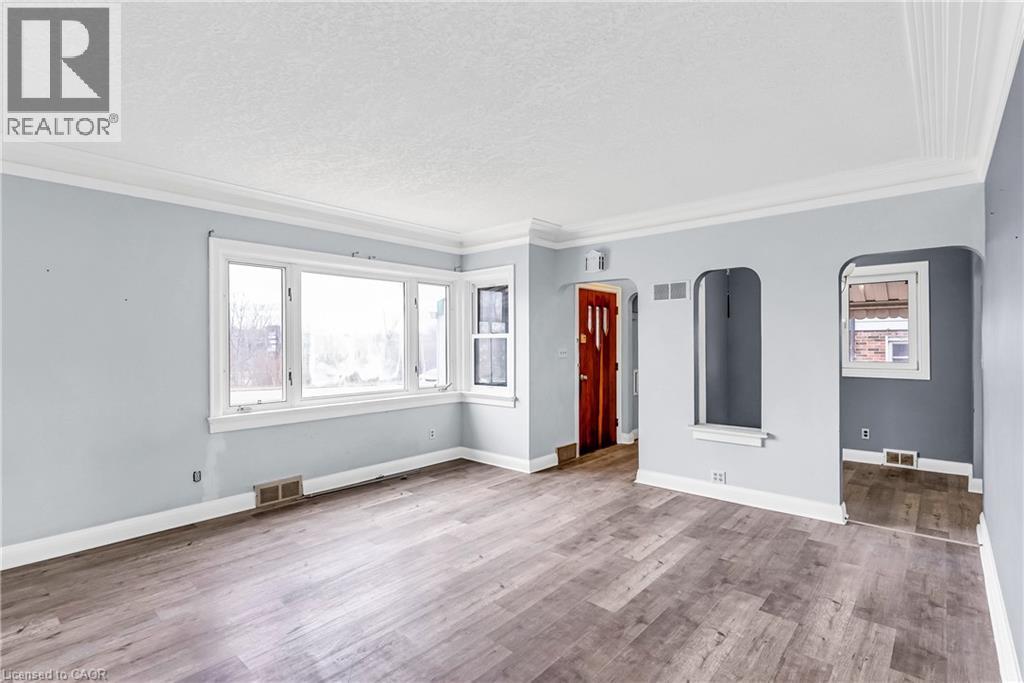 Unfurnished living room with ornamental molding, wood finished floors, a textured ceiling, and arched walkways - 41 Floral Crescent, Kitchener, ON - Indoor Photo Showing Other Room