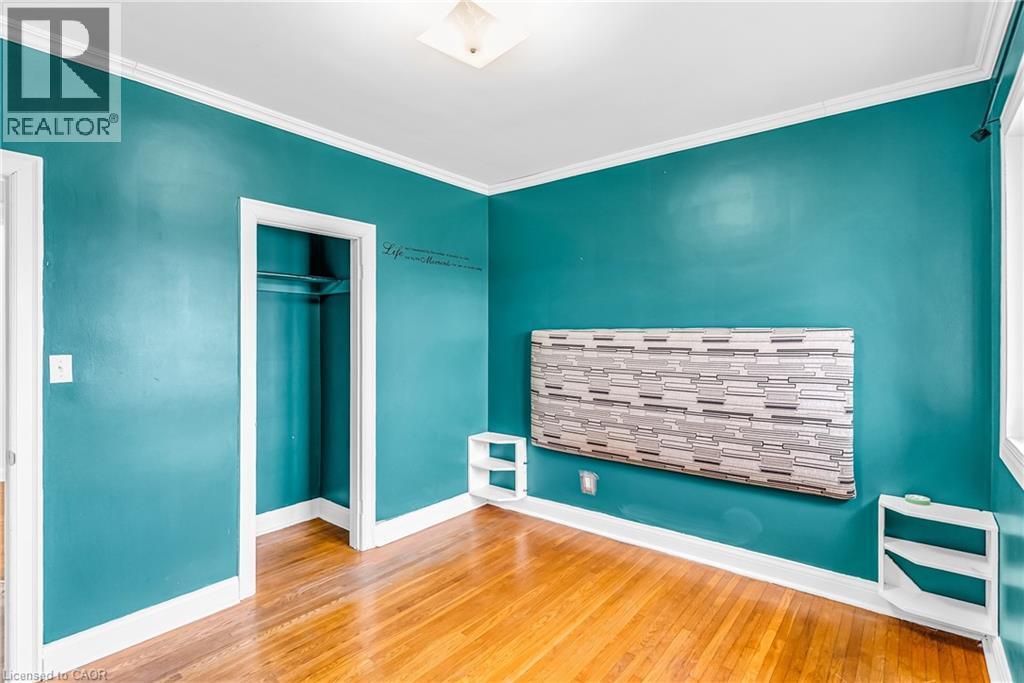 Unfurnished bedroom with hardwood / wood-style floors, crown molding, and a closet - 41 Floral Crescent, Kitchener, ON - Indoor Photo Showing Other Room