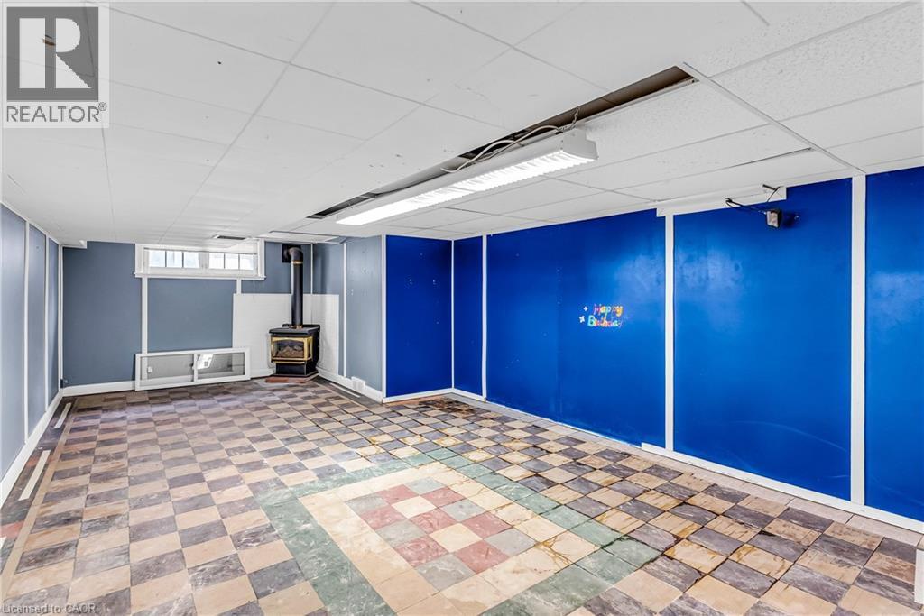 Basement with a drop ceiling and a wood stove - 41 Floral Crescent, Kitchener, ON - Indoor Photo Showing Other Room