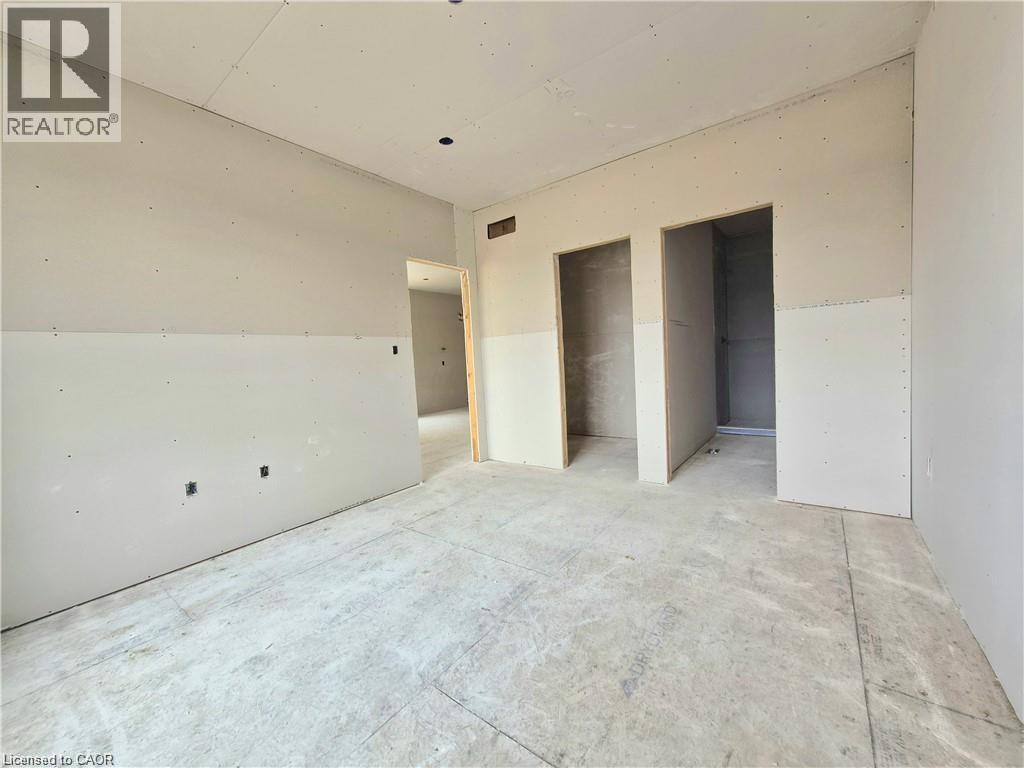 Unfurnished bedroom featuring two closets - 106 Thackeray Way, Harriston, ON - Indoor