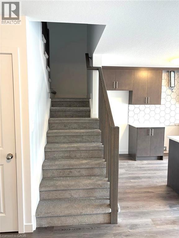 Staircase with wood finished floors and baseboards - 7 Pin Oak Common, Cambridge, ON - Indoor Photo Showing Other Room