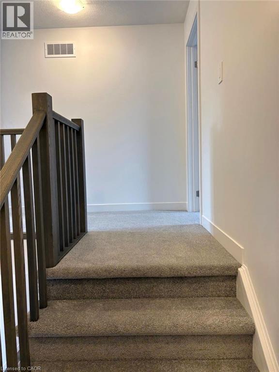 Staircase with carpet and a textured ceiling - 7 Pin Oak Common, Cambridge, ON - Indoor Photo Showing Other Room