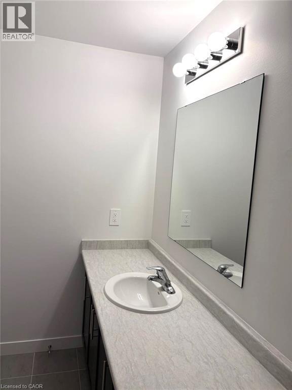 Bathroom with vanity and dark tile patterned flooring - 7 Pin Oak Common, Cambridge, ON - Indoor Photo Showing Bathroom