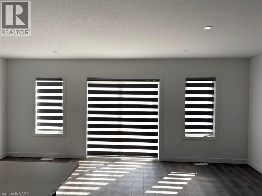 Detailed view of wood finished floors and recessed lighting - 7 Pin Oak Common, Cambridge, ON - Indoor Photo Showing Other Room