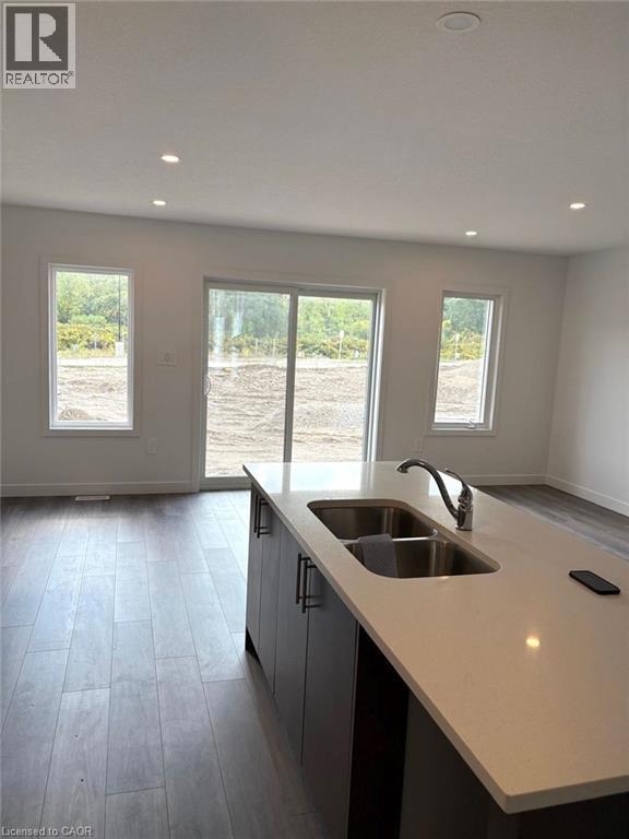 Kitchen featuring dark wood-style floors, light stone counters, recessed lighting, modern cabinets, and a center island with sink - 7 Pin Oak Common, Cambridge, ON - Indoor Photo Showing Kitchen With Double Sink