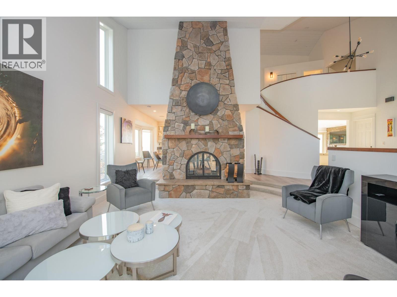 See through fireplace to dining area - 702 Cypress Drive, Coldstream, BC - Indoor Photo Showing Living Room With Fireplace