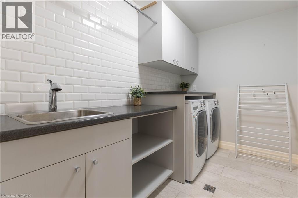 Laundry room featuring cabinet space and washer and clothes dryer - 2719 Torrey Pines Way, London, ON - Indoor Photo Showing Laundry Room