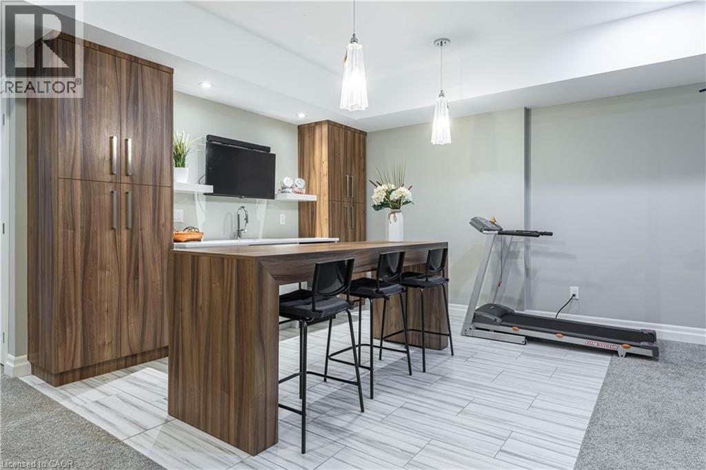 Bar area featuring wood finish cabinetry, open shelves, modern cabinets, decorative light fixtures, and butcher block counters - 2719 Torrey Pines Way, London, ON - Indoor Photo Showing Other Room