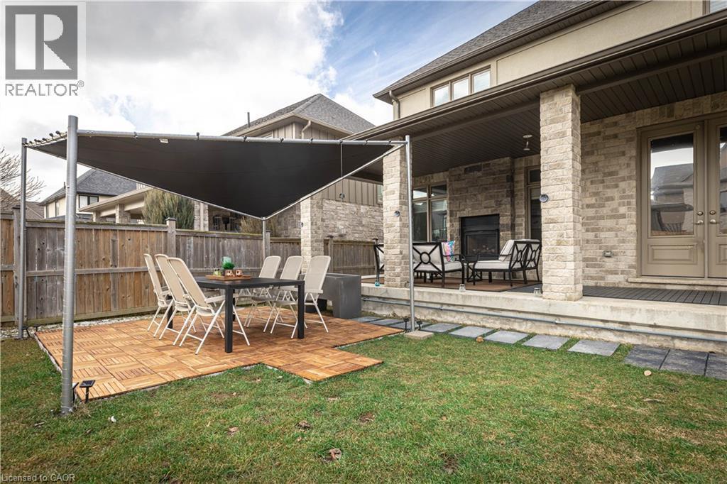 Fenced yard featuring an outdoor stone fireplace, a patio area, and outdoor dining area - 2719 Torrey Pines Way, London, ON - Outdoor With Deck Patio Veranda