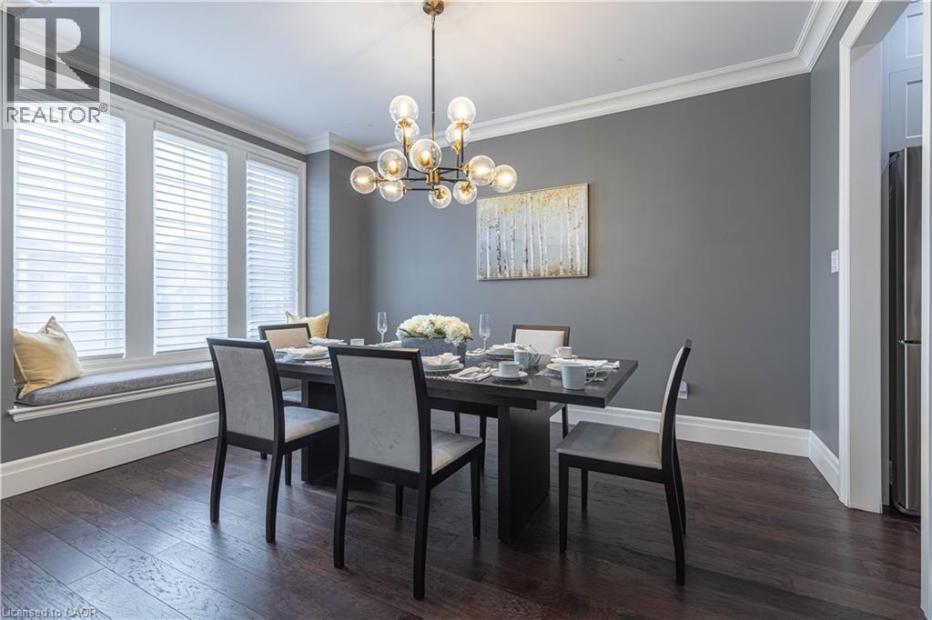Dining room featuring suspended lighting, dark wood-type flooring, and ornamental molding - 2719 Torrey Pines Way, London, ON - Indoor Photo Showing Dining Room