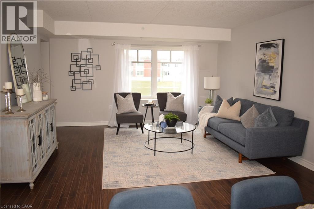 Living area featuring dark wood-type flooring and a textured ceiling - 776 Laurelwood Drive Unit# 406, Waterloo, ON - Indoor Photo Showing Living Room