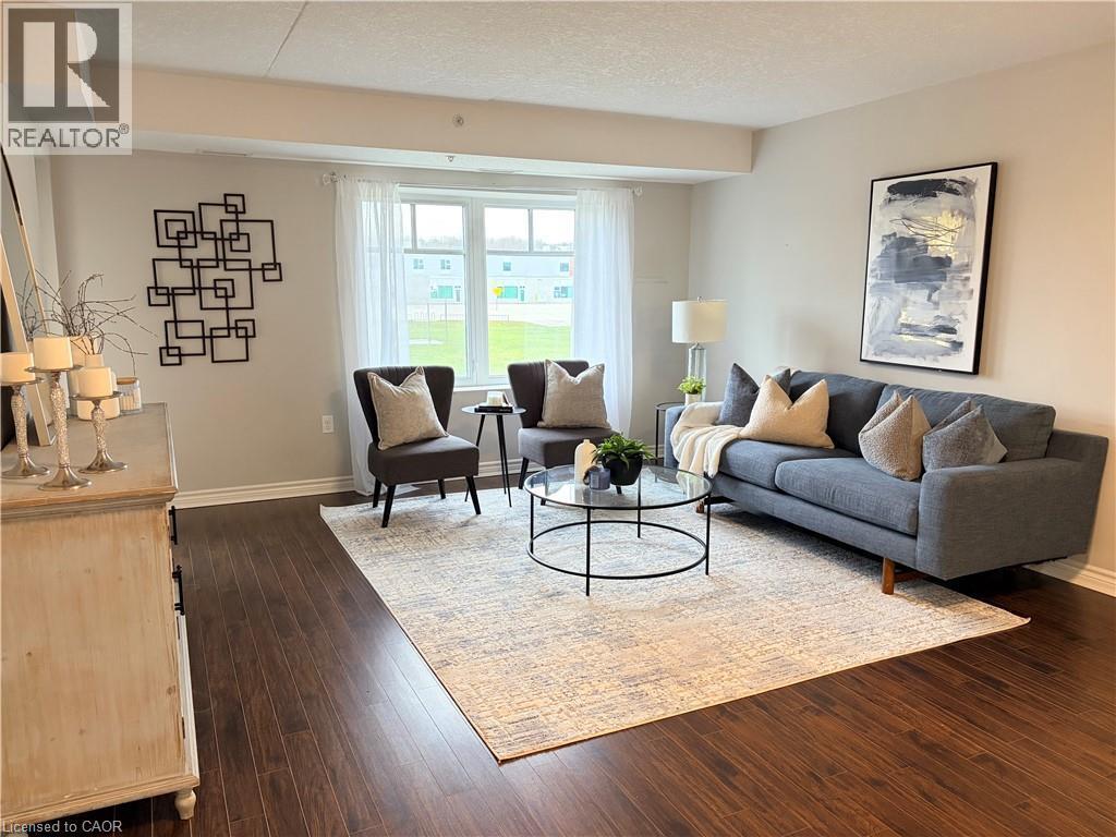 Living room with dark wood-type flooring and a textured ceiling - 776 Laurelwood Drive Unit# 406, Waterloo, ON - Indoor Photo Showing Living Room