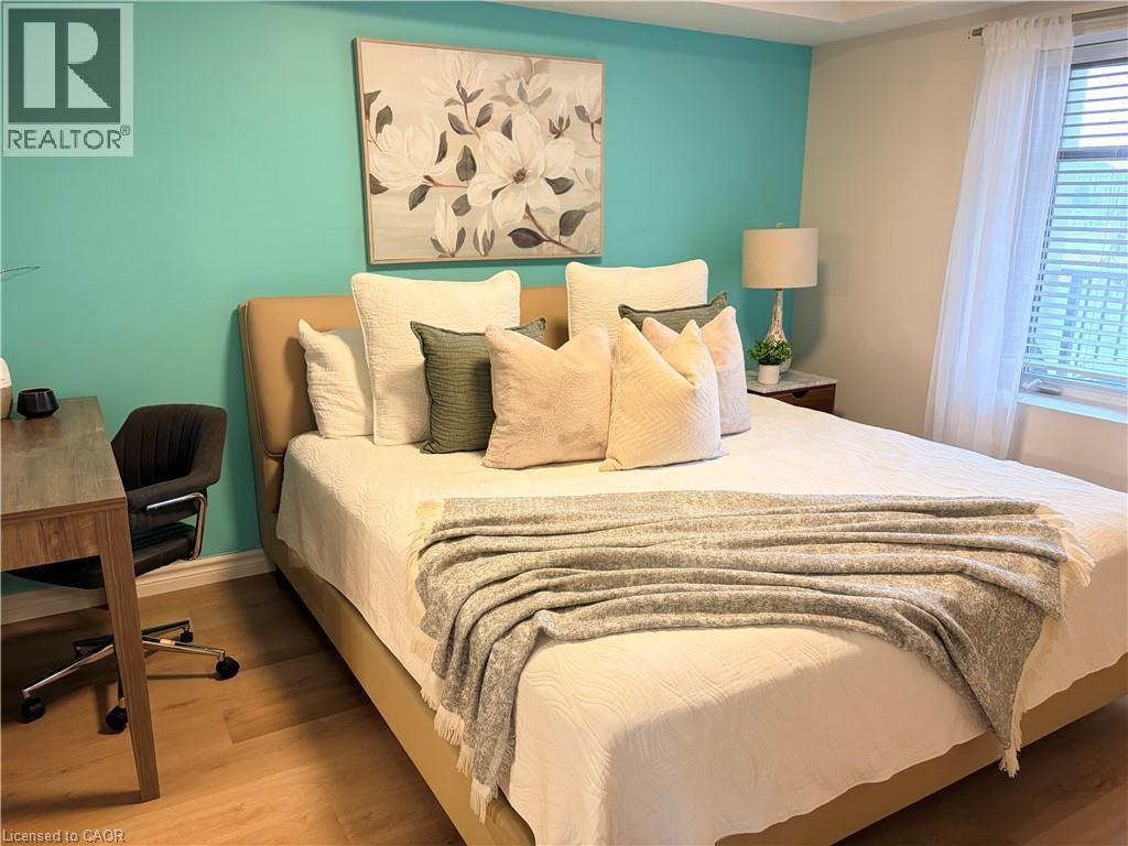 Bedroom featuring wood finished floors and an office area - 776 Laurelwood Drive Unit# 406, Waterloo, ON - Indoor Photo Showing Bedroom