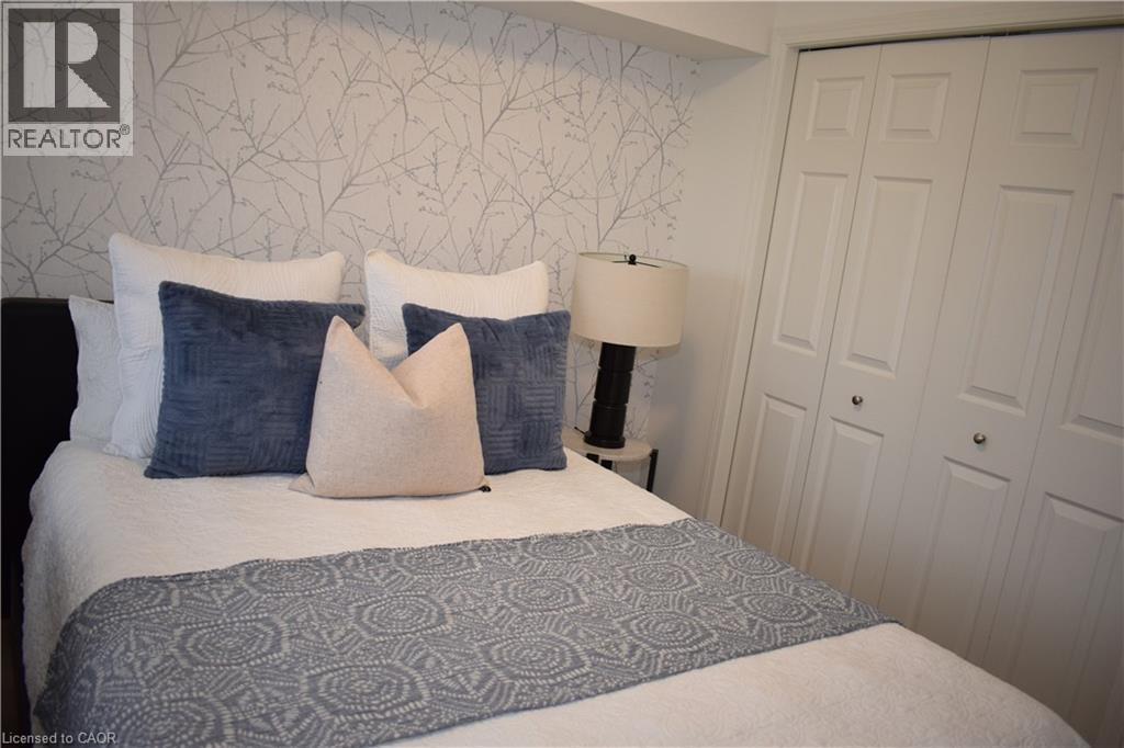 Bedroom with wallpapered walls and a closet - 776 Laurelwood Drive Unit# 406, Waterloo, ON - Indoor Photo Showing Bedroom