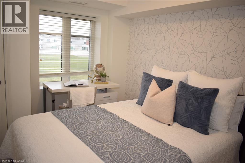 Bedroom featuring wallpapered walls and an accent wall - 776 Laurelwood Drive Unit# 406, Waterloo, ON - Indoor Photo Showing Bedroom