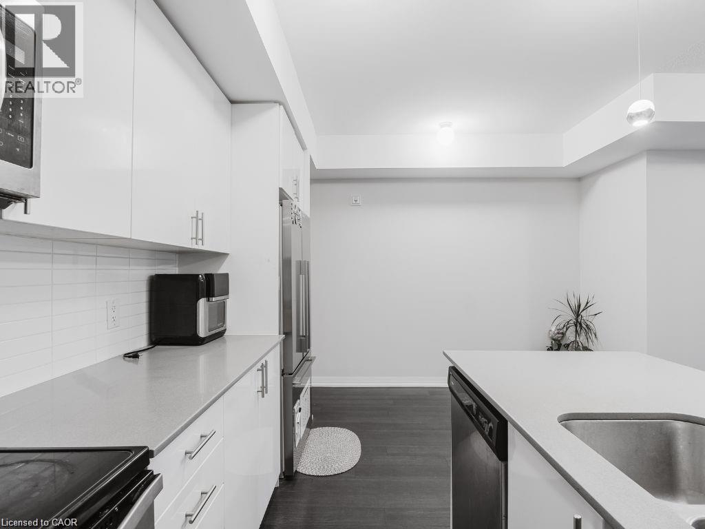Kitchen featuring white cabinets, black range with electric cooktop, dishwasher, dark wood finished floors, and high end fridge - 1206 Main Street E Unit# 113, Milton, ON - Indoor Photo Showing Kitchen