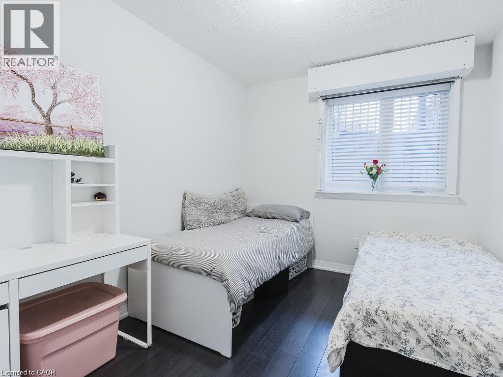 Bedroom with dark wood-style floors and a textured ceiling - 1206 Main Street E Unit# 113, Milton, ON - Indoor Photo Showing Bedroom