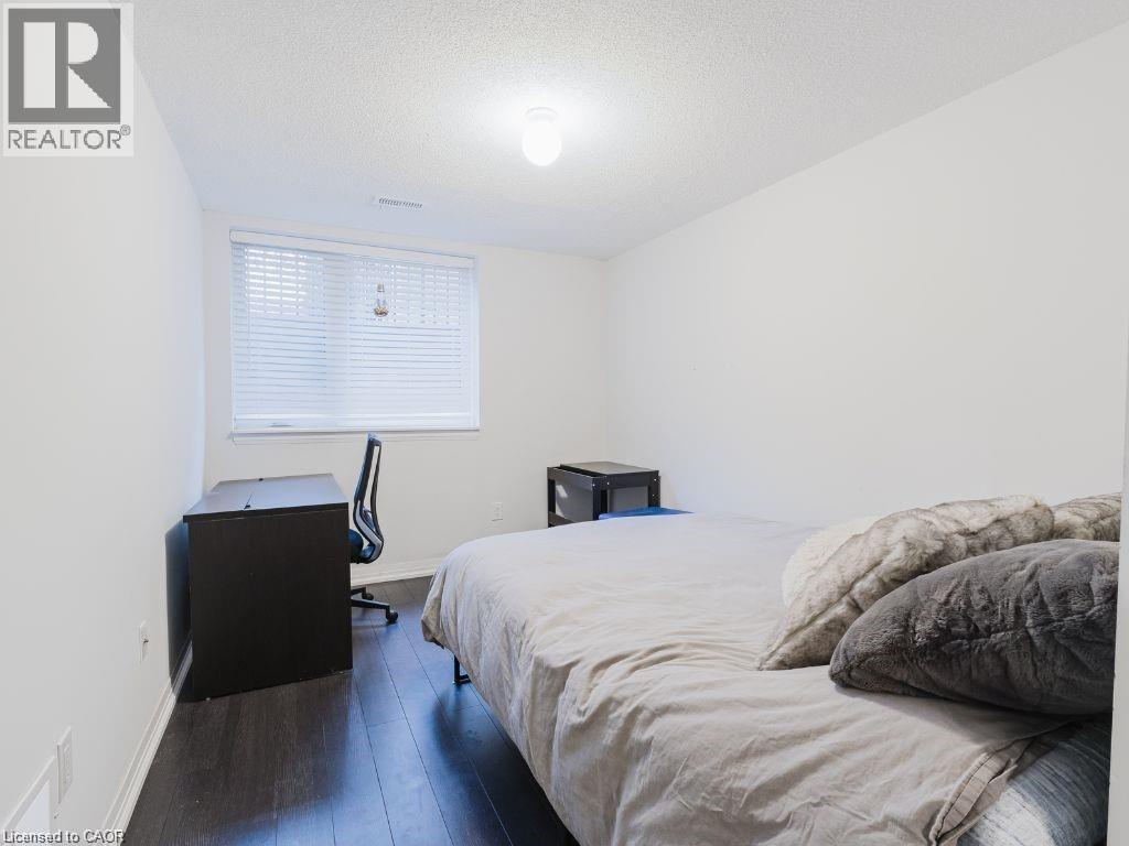 Bedroom with a textured ceiling, dark wood finished floors, and a desk - 1206 Main Street E Unit# 113, Milton, ON - Indoor Photo Showing Bedroom