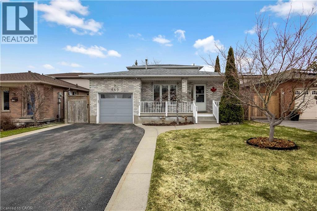 Ranch-style home with covered porch, brick siding, asphalt driveway, an attached garage, and a front lawn - 640 Acadia Drive, Hamilton, ON - Outdoor With Deck Patio Veranda