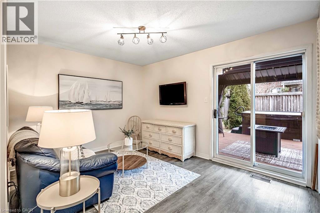 Living area with a textured ceiling and light wood-style flooring - 640 Acadia Drive, Hamilton, ON - Indoor
