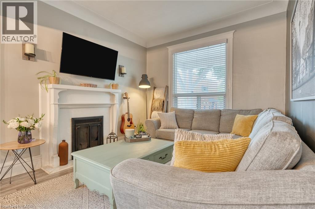 Living room featuring a glass covered fireplace and light wood-type flooring - 37 Cliff Avenue, Hamilton, ON - Indoor Photo Showing Living Room With Fireplace