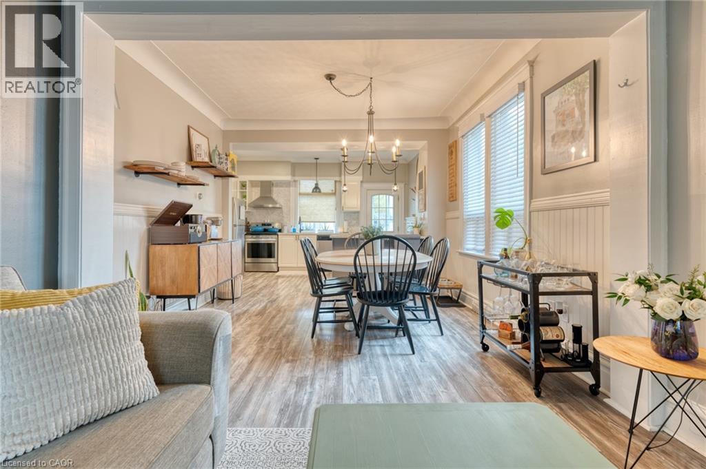 Dining room featuring a wainscoted wall, light wood-type flooring, suspended lighting, and crown molding - 37 Cliff Avenue, Hamilton, ON - Indoor