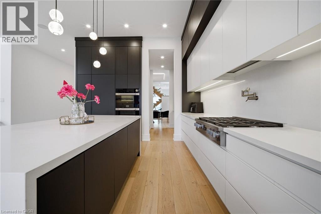 Kitchen featuring two tone cabinets, modern cabinets, light wood-type flooring, and stainless steel gas stovetop - 2556 Glengarry Road, Mississauga, ON - Indoor Photo Showing Kitchen With Upgraded Kitchen