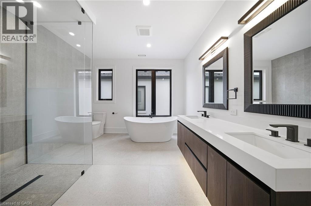 Bathroom with double vanity, a freestanding bath, walk in shower, and recessed lighting - 2556 Glengarry Road, Mississauga, ON - Indoor Photo Showing Bathroom