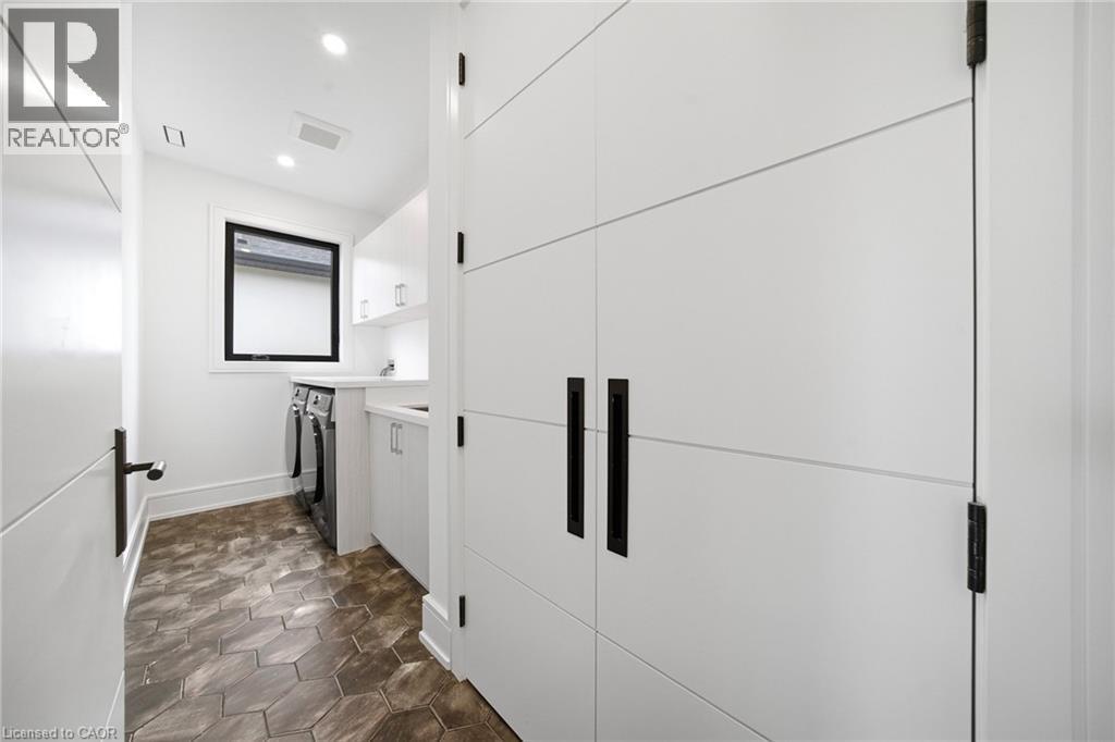 Laundry area featuring cabinet space, stone finish floors, recessed lighting, and washer and clothes dryer - 2556 Glengarry Road, Mississauga, ON - Indoor Photo Showing Other Room