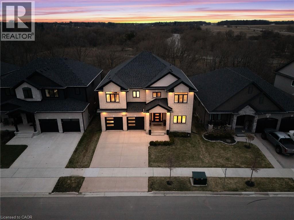 Modern farmhouse style home featuring concrete driveway, a lawn, and an attached garage - 39 Mill Race Crescent, St. Jacobs, ON - Outdoor With Facade