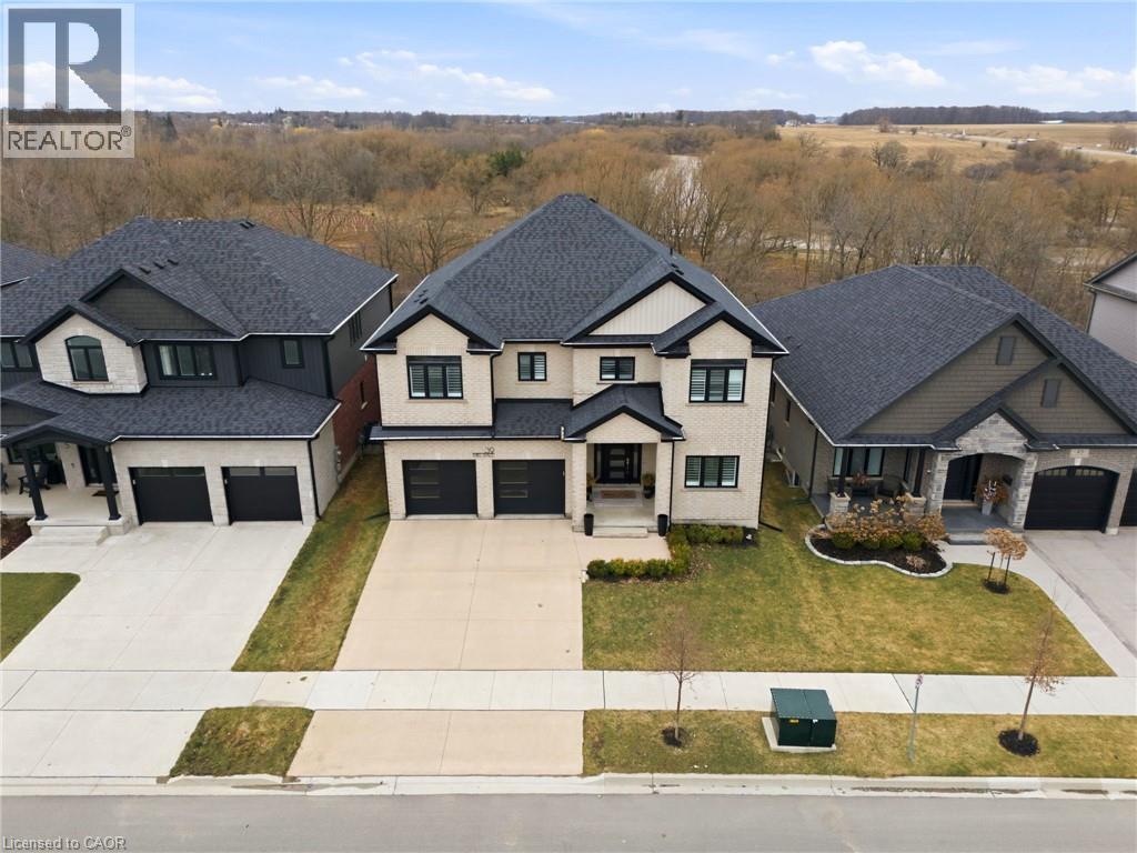View of front of home with concrete driveway, an attached garage, a porch, roof with shingles, and a front yard - 39 Mill Race Crescent, St. Jacobs, ON - Outdoor With Facade