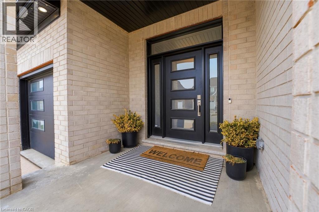 Property entrance featuring brick siding, a garage, and covered porch - 39 Mill Race Crescent, St. Jacobs, ON - Outdoor With Exterior