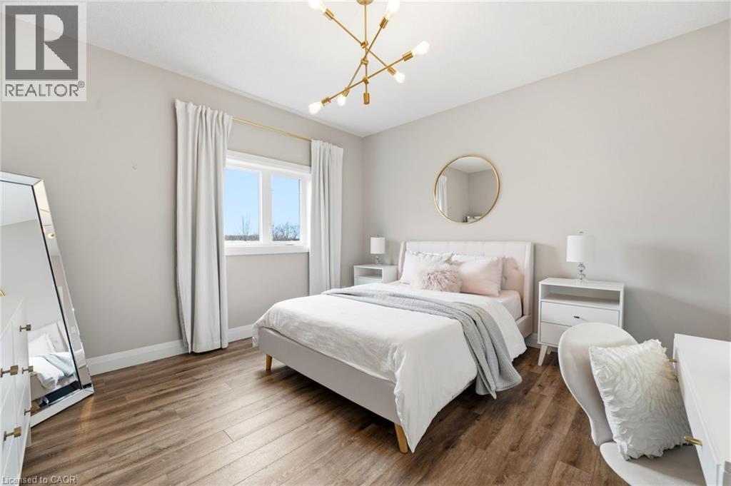 Bedroom featuring wood finished floors and a chandelier - 39 Mill Race Crescent, St. Jacobs, ON - Indoor Photo Showing Bedroom