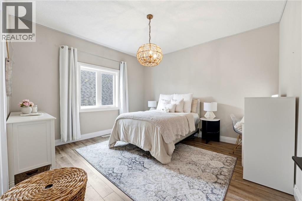 Bedroom with light wood-style flooring and suspended lighting - 39 Mill Race Crescent, St. Jacobs, ON - Indoor Photo Showing Bedroom