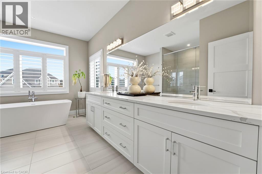 Full bathroom featuring a stall shower, double vanity, light tile patterned flooring, and a soaking tub - 39 Mill Race Crescent, St. Jacobs, ON - Indoor Photo Showing Bathroom