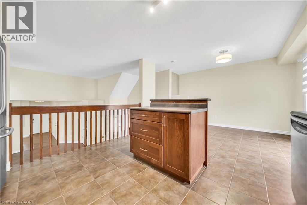 Kitchen with a kitchen island, wood finish cabinetry, stainless steel appliances, and light tile patterned floors - 51 Seabrook Drive, Kitchener, ON - Indoor Photo Showing Other Room