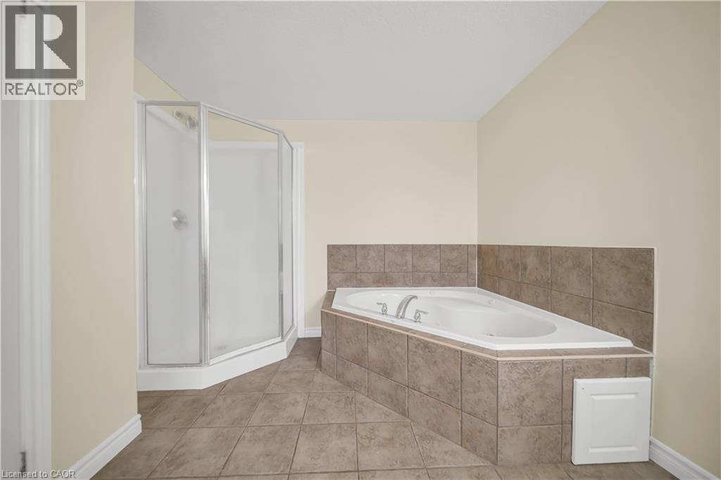 Full bath with a stall shower, tile patterned floors, and a garden tub - 51 Seabrook Drive, Kitchener, ON - Indoor Photo Showing Bathroom