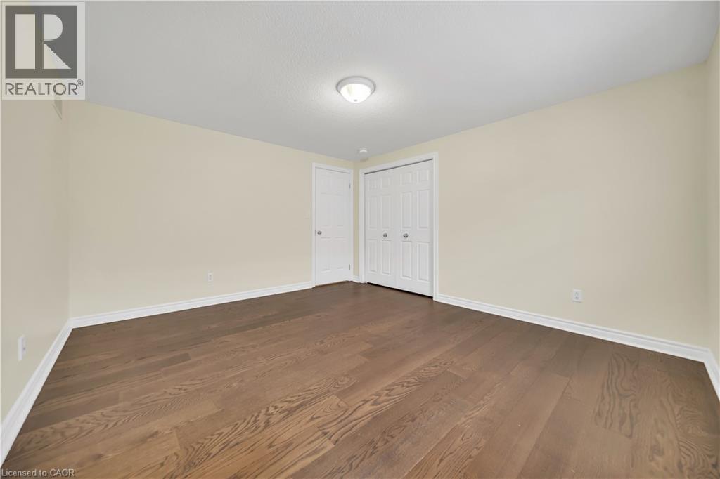 Unfurnished bedroom featuring dark wood-style flooring and a closet - 51 Seabrook Drive, Kitchener, ON - Indoor Photo Showing Other Room