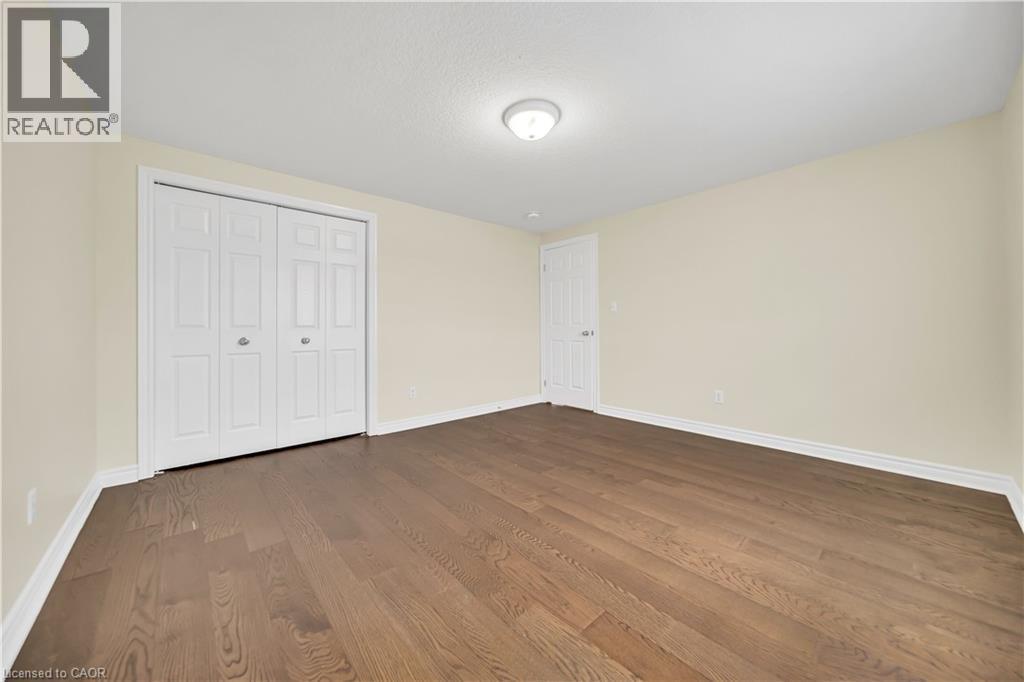 Unfurnished bedroom with dark wood-style floors and a closet - 51 Seabrook Drive, Kitchener, ON - Indoor Photo Showing Other Room