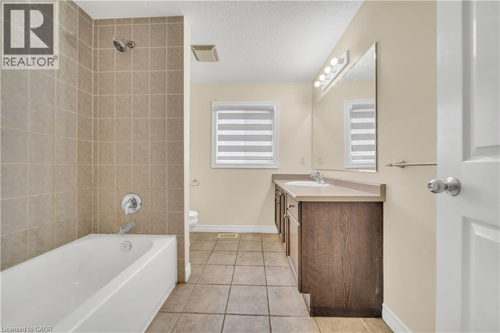 Bathroom featuring vanity, light tile patterned floors, shower / tub combination, and a textured ceiling - 51 Seabrook Drive, Kitchener, ON - Indoor Photo Showing Bathroom