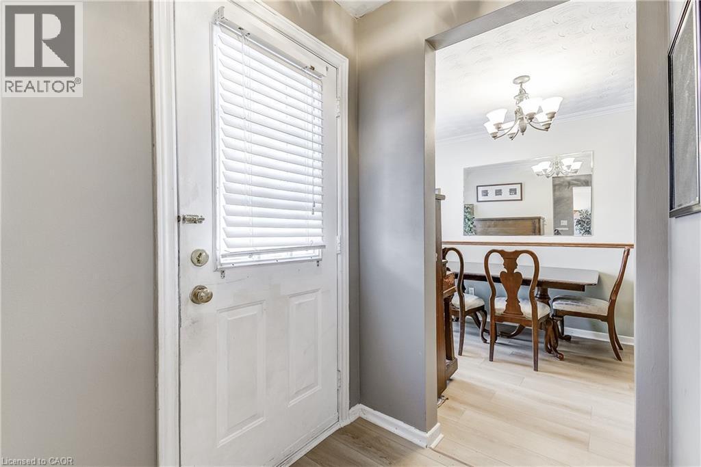 Entrance foyer featuring light wood finished floors, a chandelier, and crown molding - 2145 Sandringham Drive, Burlington, ON - Indoor Photo Showing Other Room