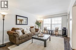 Living room with crown molding and dark wood-type flooring -