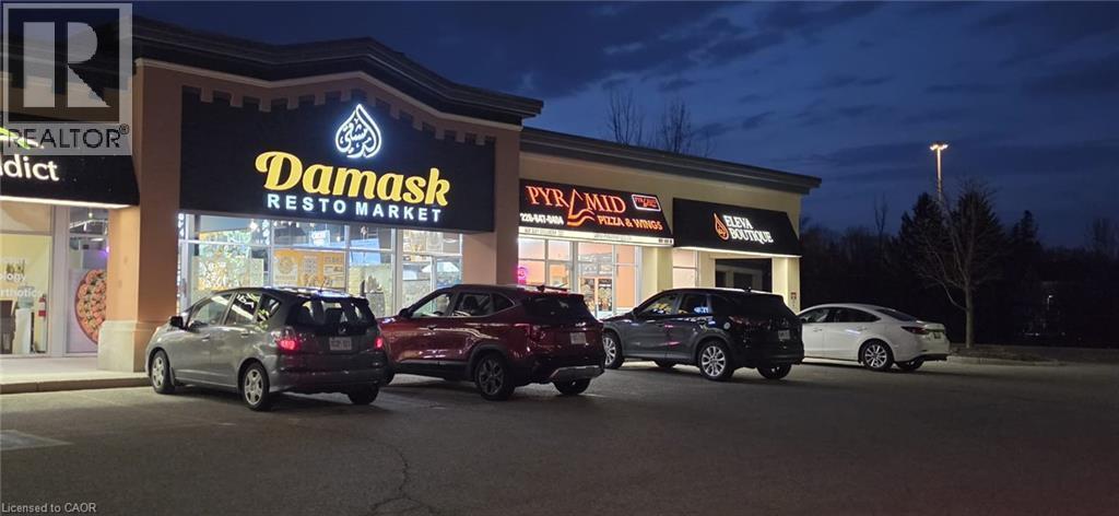 Property at twilight featuring view of commercial area and uncovered parking - 645 Westmount Road E Unit# 8, Kitchener, ON