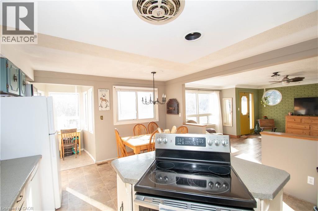 Kitchen featuring electric range, freestanding refrigerator, a ceiling fan, and open floor plan - 535 Mcdowell Road E, Simcoe, ON