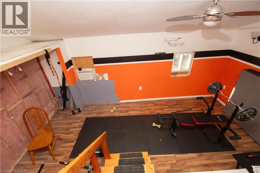 Workout area featuring wood finished floors and a ceiling fan used to be the garage - 535 Mcdowell Road E, Simcoe, ON