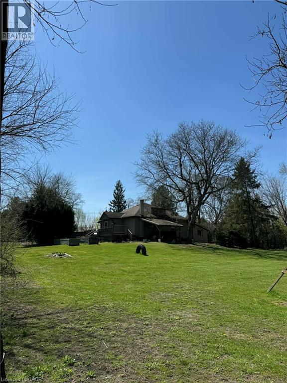 Expansive green lawn with a gentle slope leading to a traditional-style residence - 535 Mcdowell Road E, Simcoe, ON