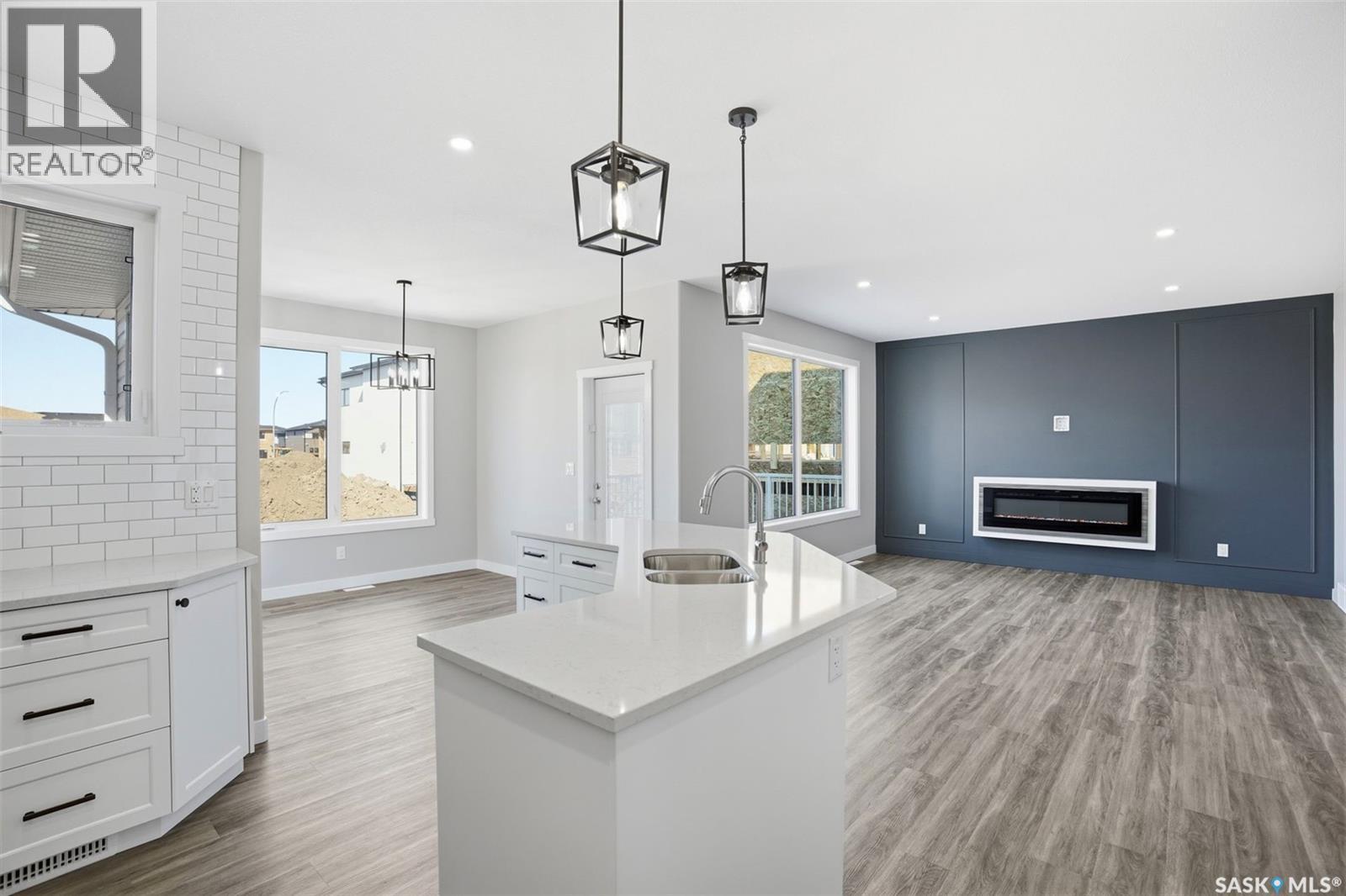 203 Sharma Lane, Saskatoon, SK - Indoor Photo Showing Kitchen With Fireplace With Double Sink
