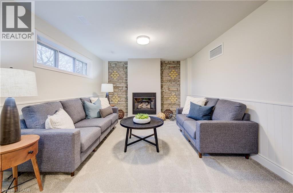 Orignal brickwork fireplace wall adds to the mid-century charm of this home. Cozy up next to the gas fireplace and relax with a good book. - 66 Tupper Crescent, Kitchener, ON - Indoor Photo Showing Living Room With Fireplace